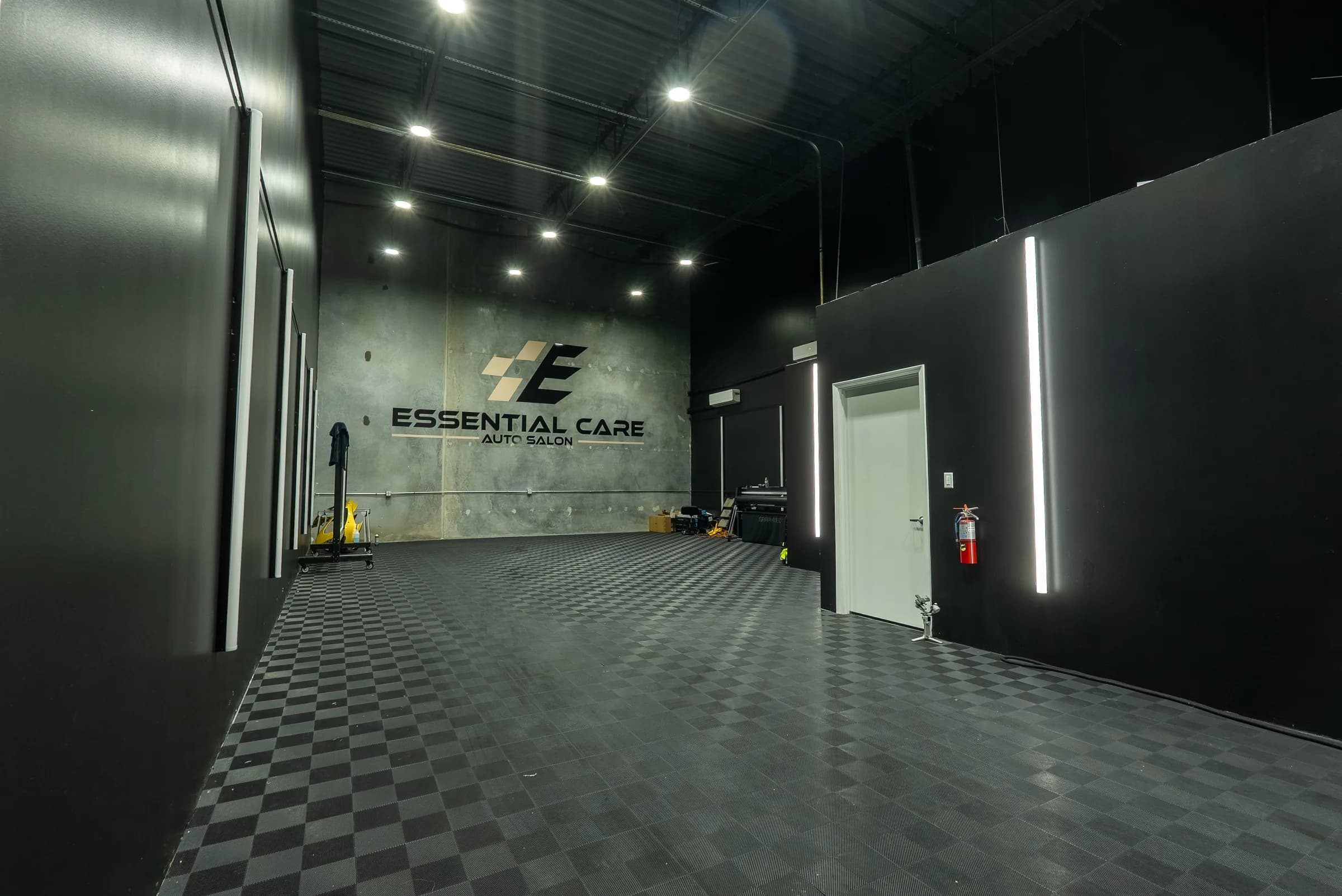 Install bay with the Essential Care Auto Salon logo on a polished concrete wall