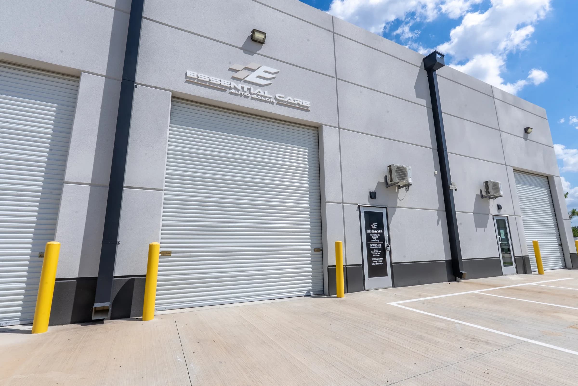 Exterior of the Essential Care Auto Salon building with the roll-up bay door and front office entrance
