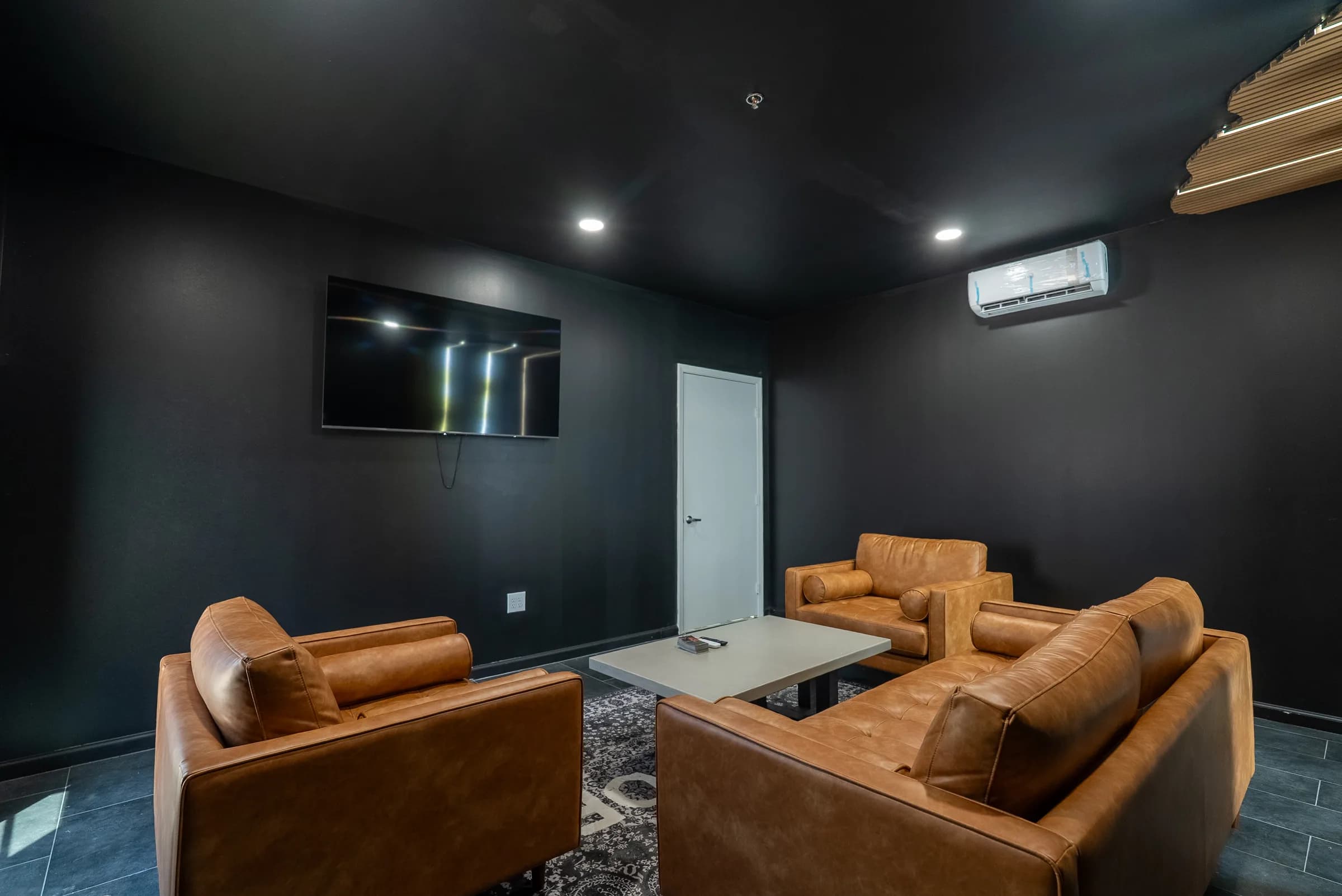 Client lounge seating area with leather sofas and a wall-mounted TV